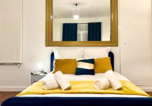 a bedroom with a bed with a mirror above it at Le Charme D'Antan in Évreux