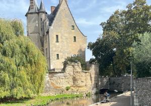 a man sitting on a bench in front of a castle at Le Charme D'Antan - Terrasse - Balcon - Hypercentre Evreux in Évreux