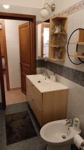 a bathroom with a sink and a toilet and a mirror at Mina Home in Gorizia