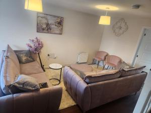 a living room with a couch and two chairs at Glamshouse in Bushbury