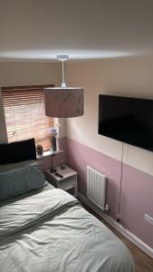 a bedroom with a bed and a flat screen tv at Glamshouse in Bushbury