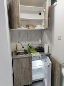 una pequeña cocina con fregadero y nevera abierta en Vikendica Aki, en Zajecar