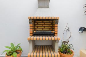 eine mit Mauerwerk befeuerte, materiell-materiell-materiell-materiell-materiell-materiell-materiell-materiell-materiell-materiell-materiell-materiell-materiell-materiell in der Unterkunft Canto do Atlantico - City Centre with Air Conditioning, Private Garage and Outdoor Patio in Ponta Delgada