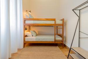 a room with two bunk beds and a rug at Canto do Atlantico - City Centre in Ponta Delgada