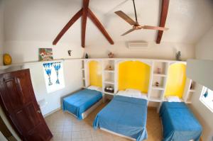 a room with two beds and a ceiling fan at Surf Sanctuary in El Limón
