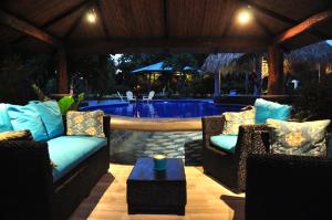 a patio with two chairs and a swimming pool at Surf Sanctuary in El Limón