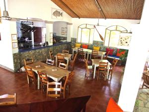 ein Restaurant mit Tischen und Stühlen und einer Theke in der Unterkunft Surf Sanctuary in El Limón