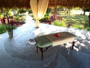 a bed on a table under a umbrella at Surf Sanctuary in El Limón