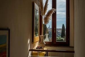 un jarrón sentado en un estante frente a una ventana en Villa Elvira 1931 en Siena