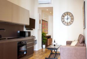 a kitchen and living room with a clock on the wall at BAYRIA HOME in Bari