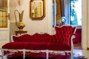 a red couch in a room with a mirror at Villa Elvira 1931 in Siena