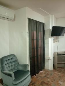 ein Wohnzimmer mit einem Stuhl und einem TV in der Unterkunft Estudio Comodo y Tranquilo in Mexicali