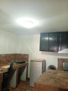 eine Küche mit schwarzen Schränken und einer Arbeitsplatte in der Unterkunft Estudio Comodo y Tranquilo in Mexicali