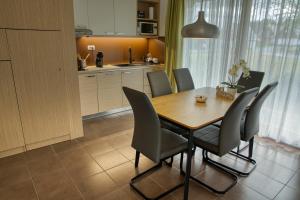 uma cozinha e sala de jantar com uma mesa de madeira e cadeiras em Apartma Pikabooth em Topolšica