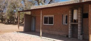 a brick building with a window and a door at TINKUNAKAMA in Humahuaca