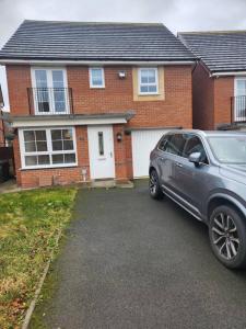 a silver car parked in front of a house at Glamshouse in Bushbury