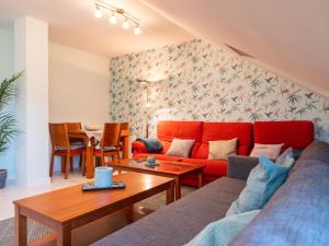 a living room with a red couch and a table at Apartamento "MARINA" in Tordesillas