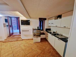 a large kitchen with white cabinets and a sink at Casa vacanza Castello in Cagliari