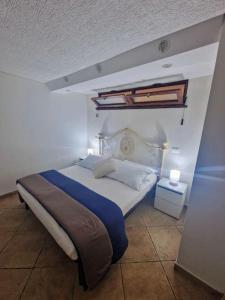 una camera da letto con un grande letto con una coperta blu di Casa vacanza Castello a Cagliari
