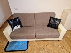 un divano marrone con due cuscini su un pavimento di Casa vacanza Castello a Cagliari