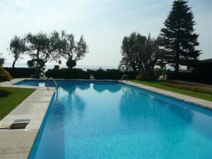 una gran piscina azul en un patio en Holiday Garda Villa Dolcelago Lake Front, en Moniga del Garda