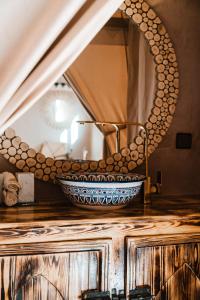 a bowl on a counter in front of a mirror at Tiziri Camp in Merzouga