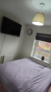 a bedroom with a bed and a clock on the wall at Glamshouse in Bushbury