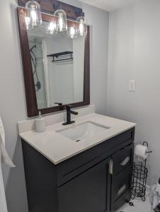 La salle de bains est pourvue d'un lavabo et d'un miroir. dans l'établissement Adorable 4 bed,2 bath house, à Kingston