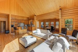 a living room with white furniture and a wooden ceiling at Fiddler Lake Resort Chalet Deer 59 in Mille-Isles