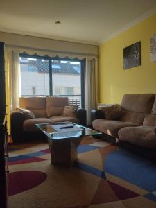 ein Wohnzimmer mit 2 Sofas und einem Couchtisch in der Unterkunft AGARIMO APARTAMENTO in Pontevedra