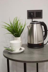 a tea kettle and a cup on a table with a plant at Lux Plaza (New Rooms) in Pʼarakʼar