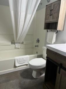 La salle de bains blanche est pourvue de toilettes et d'un lavabo. dans l'établissement Heritage Inn Express, à Marysville