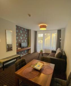 a living room with a couch and a table at Happy Seasons Szoboszló in Hajdúszoboszló