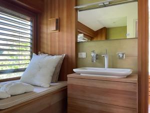 La salle de bains est pourvue d'un lavabo et d'un miroir. dans l'établissement Chalet Ly's Nest, à Aldino
