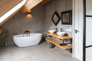 a bathroom with a large tub and two sinks at Luxe Retreatsecret Of Ledeacker 