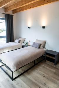 two beds in a room with wooden ceilings at Luxe Retreatsecret Of Ledeacker 