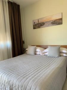 Un dormitorio con una cama grande con sábanas blancas. en Le Giare, en Verona