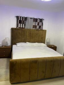 a large bed in a bedroom with two night stands at Residencial altos de la independencia in San Pedro de Macorís