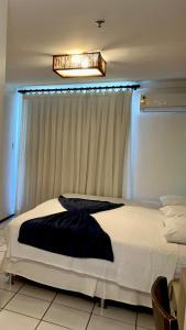 a bedroom with a large white bed in front of a window at Gran Lençóis Flat Barreirinhas in Barreirinhas