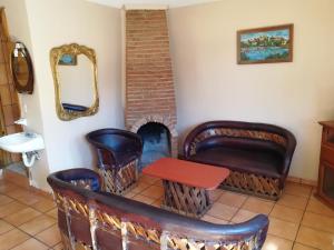 a room with chairs and a table and a mirror at El Mesón de Don Quijote in Mazamitla