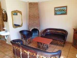 a room with leather chairs and a table and a mirror at El Mesón de Don Quijote in Mazamitla