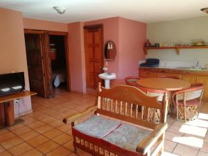 a living room with a table and a kitchen at El Mesón de Don Quijote in Mazamitla