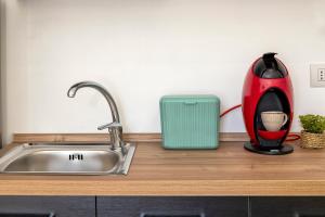 a kitchen counter with a sink and a red vase at Delia's Home in Alghero +60 photos