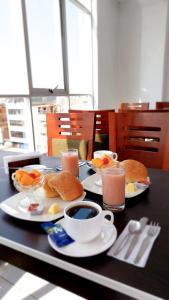 una mesa con platos de comida y bebidas. en Samaná Hostal en Tacna