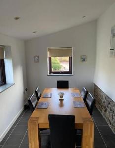 a conference room with a wooden table and chairs at Trelowen Cottage in Callington