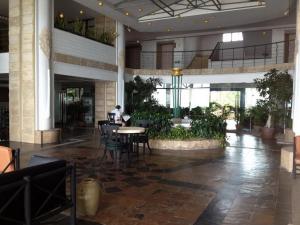 a person sitting at a table in a lobby at Beach Holiday in Cha Am