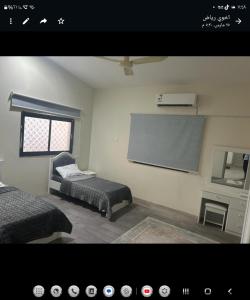 une chambre avec deux lits et un écran de projection dans l'établissement فيلا مع مزرعة صغيرة في اعلى قرية بالباحة, à Al Baha