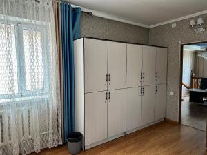 a room with white cabinets and a large window at Hostel 4U in Bishkek