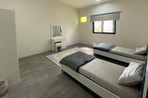 a small bedroom with two beds and a tv at فيلا مع مزرعة صغيرة في اعلى قرية بالباحة in Al Baha