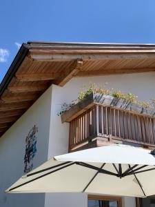 a white umbrella in front of a building with a balcony at Chalet Ly's Nest in Aldino